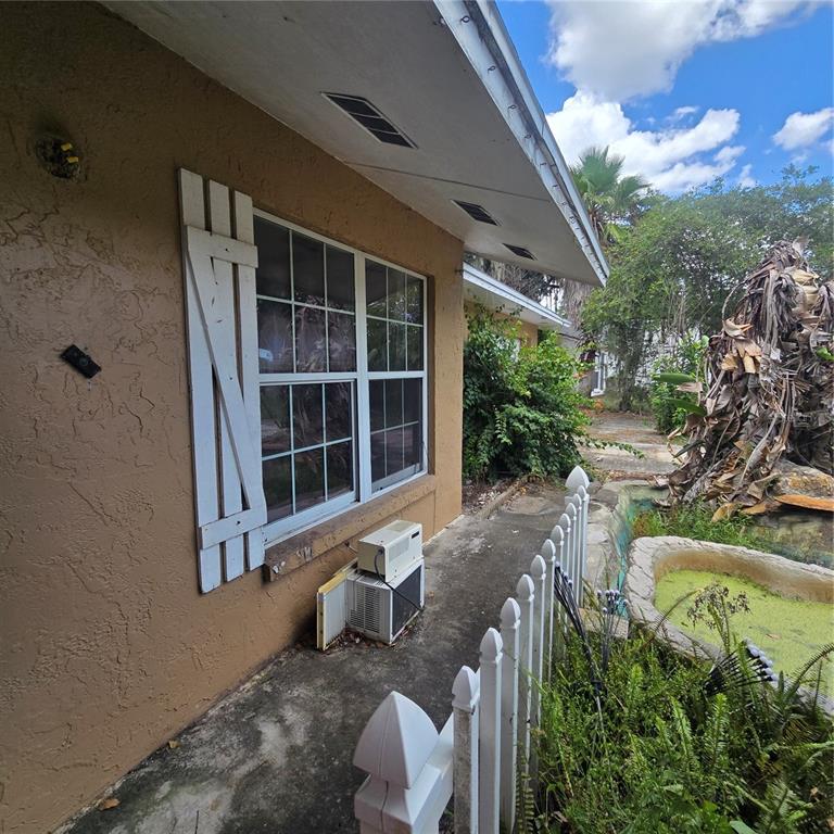 An exterior view of a house with a window, white shutters, and a small air conditioner — 5127 BLACK BIRCH TRAIL, MULBERRY, FL