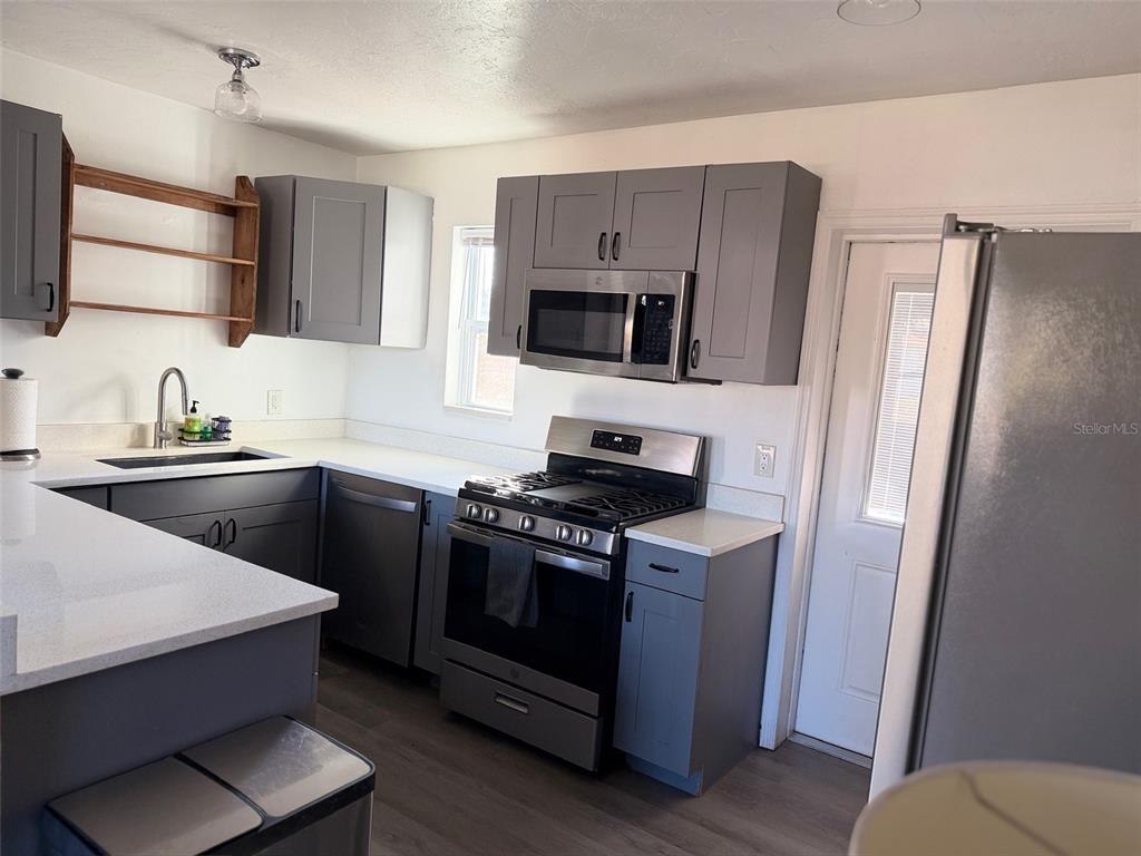 A kitchen features gray cabinets, stainless steel appliances, and white countertops — 9372 88TH WAY, SEMINOLE, FL