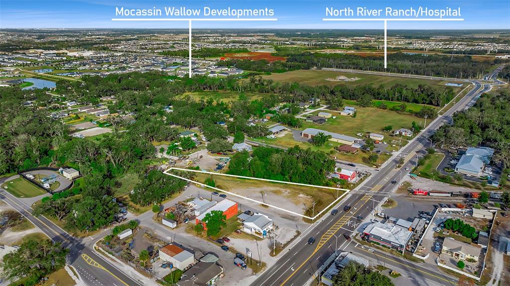 An aerial view shows a vacant, triangular-shaped lot situated along a paved road — 12346 US-301, PARRISH, FL