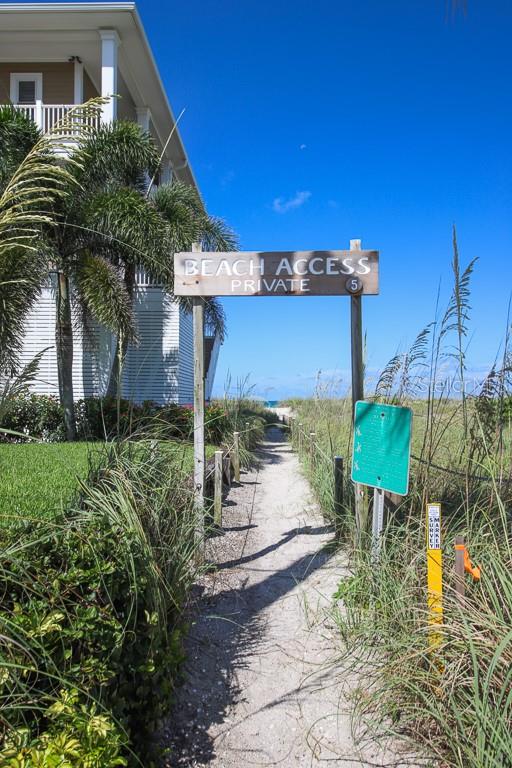 A sandy path leads through beach grass toward a private beach access sign — 14 BAYSHORE CIRCLE, PLACIDA, FL