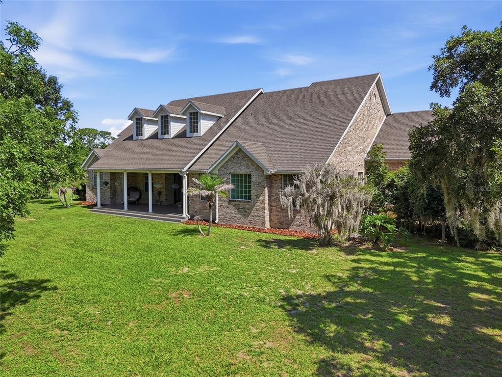 An aerial view shows a house, a red barn, and a pond on a grassy lot — 13525 PALM DRIVE, ASTATULA, FL