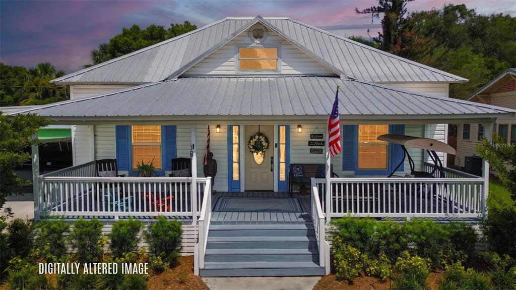 A white house with a metal roof and a large front porch featuring blue shutters — 520 S JACKSON AVENUE, BARTOW, FL