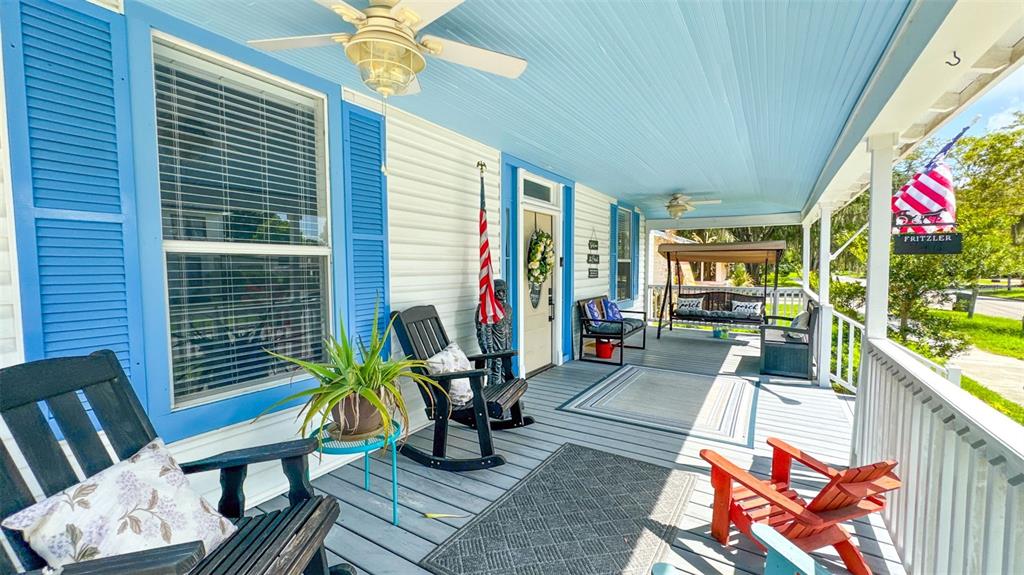 A covered front porch features blue trim, a ceiling fan, rocking chairs, and a porch swing — 520 S JACKSON AVENUE, BARTOW, FL