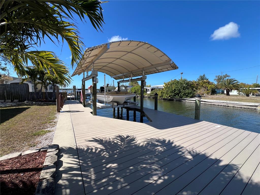 A boat lift with a canopy sits at the end of a wooden dock — 2650 COCO PLUM DRIVE, MATLACHA, FL