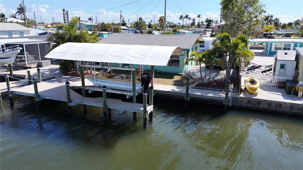 An aerial view shows a house with a boat lift and dock on the water — 2650 COCO PLUM DRIVE, MATLACHA, FL