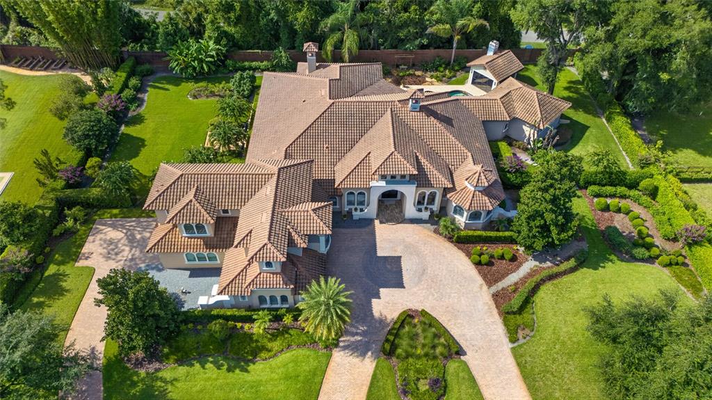 An aerial view of a large house with a tiled roof and a paved driveway — 7765 ISLEWOOD COURT, SANFORD, FL