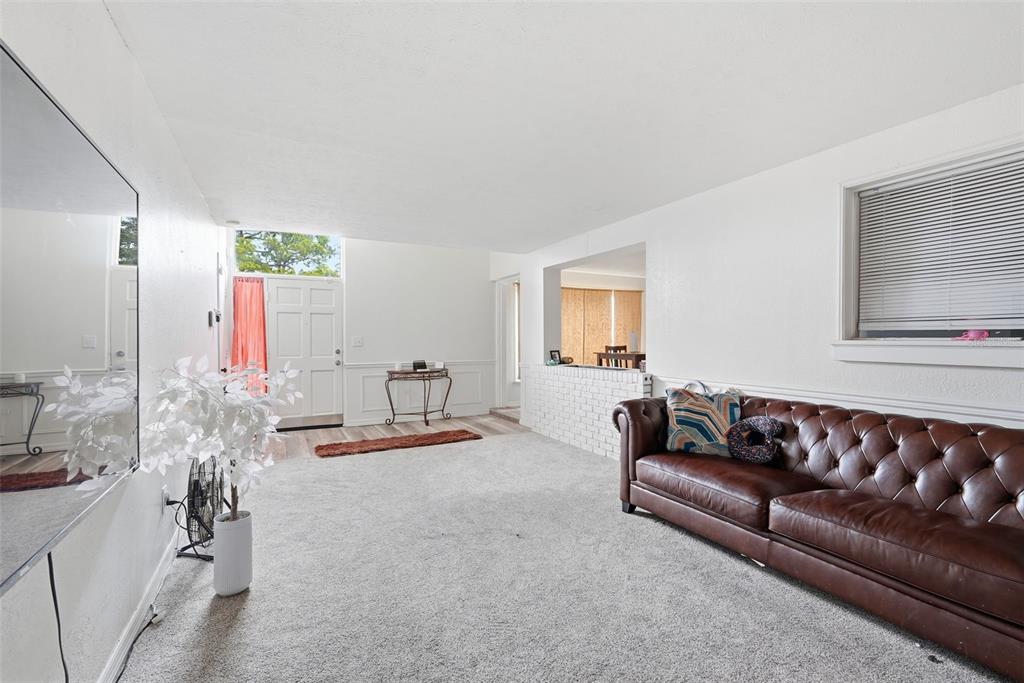 A living room features a brown leather sofa, white walls, and a white brick partition — 1709 CARNEGIE CIRCLE, TAMPA, FL