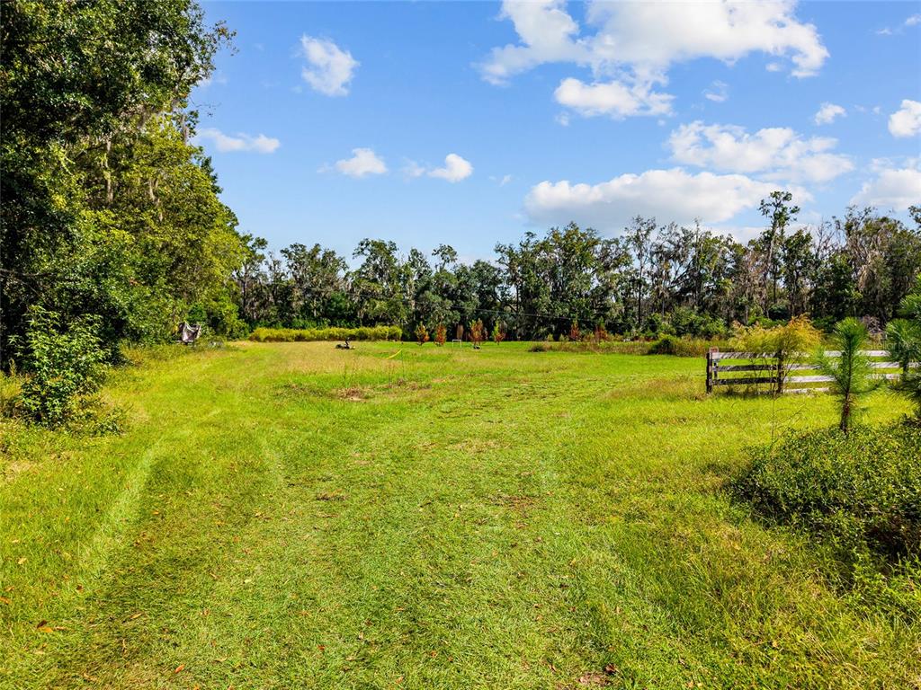 A grassy, open field is bordered by a wooden fence and a line of trees — 8543 NW 71 TERRACE, GAINESVILLE, FL