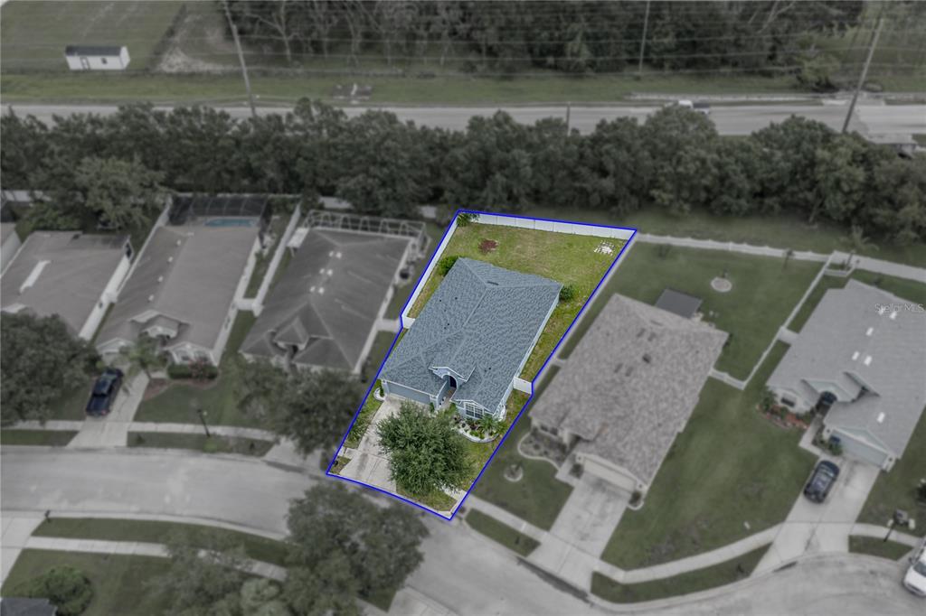 An aerial view shows a single-family house with a fenced backyard in a suburban neighborhood — 34455 CLIFFCREEK COURT, WESLEY CHAPEL, FL