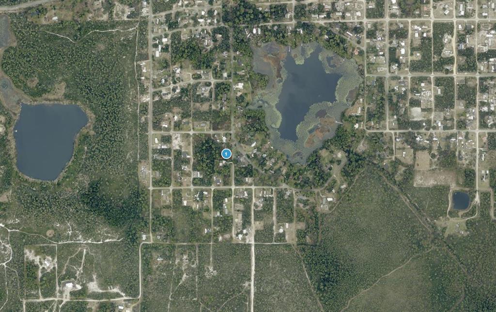 This is an aerial map view of a residential area featuring a lake and woods — 15-17-28-0100-021-00900 PENNSYLVANIA STREET, PAISLEY, FL