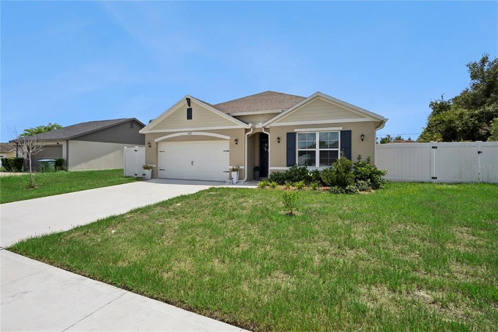 A single-story house with a beige exterior, white garage door, and a front lawn — 2073 SWANSON DRIVE, DELTONA, FL