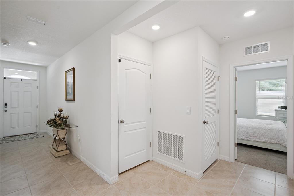 A bright entryway features tiled floors, white walls, two interior doors, and a bedroom doorway — 2073 SWANSON DRIVE, DELTONA, FL