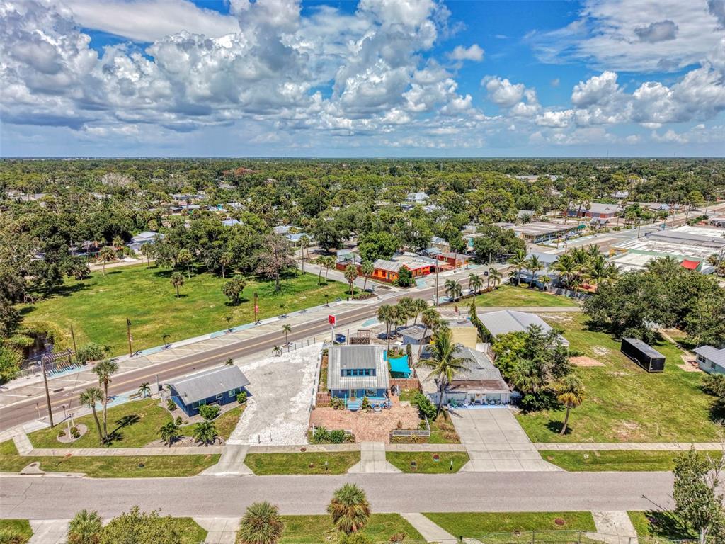 An aerial view shows a residential street with houses, palm trees, and a nearby road — 530 W GREEN STREET, ENGLEWOOD, FL