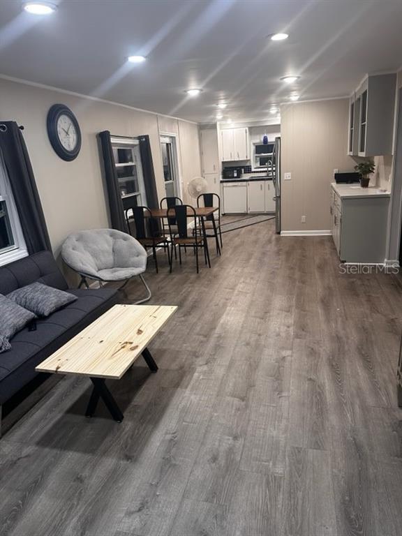 An open-concept living and dining area features wood-look flooring, recessed lighting, and a kitchen — 530 SUN UP STREET, NORTH FORT MYERS, FL