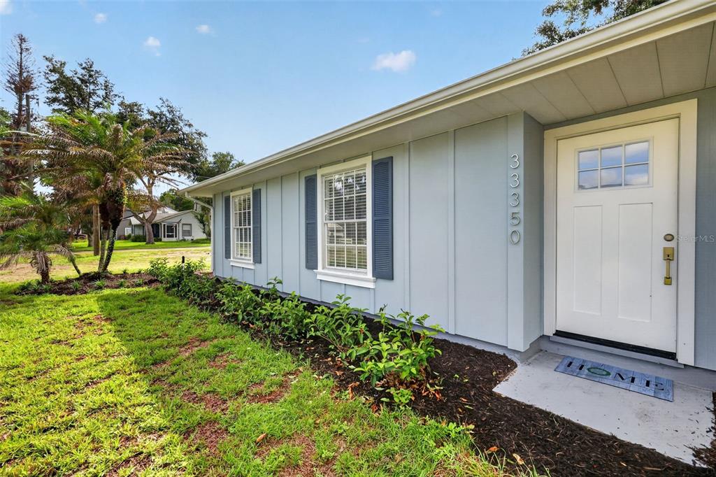 The exterior of a light blue house features a white front door and two windows — 33350 E LAKE JOANNA DRIVE, EUSTIS, FL
