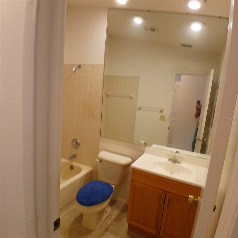 A bathroom features a vanity with a wood cabinet, a toilet, and a shower-tub combination — 9362 NAKOMA WAY, WEEKI WACHEE, FL