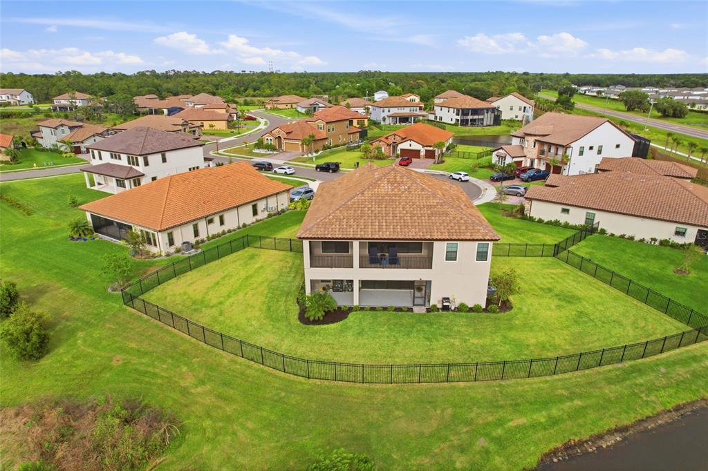 An aerial view shows a two-story house with a fenced backyard and a tile roof — 8207 RUSHTON PLACE, PARRISH, FL