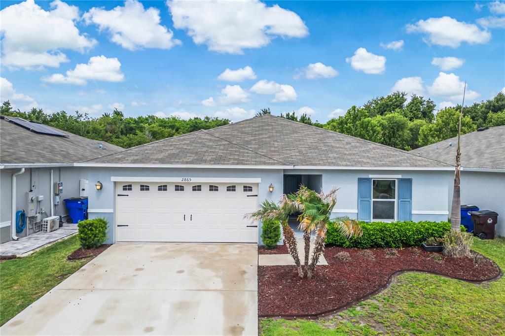 An aerial view shows a single-story house with a two-car garage and a landscaped yard — 2865 MOSSHIRE CIRCLE, ST CLOUD, FL