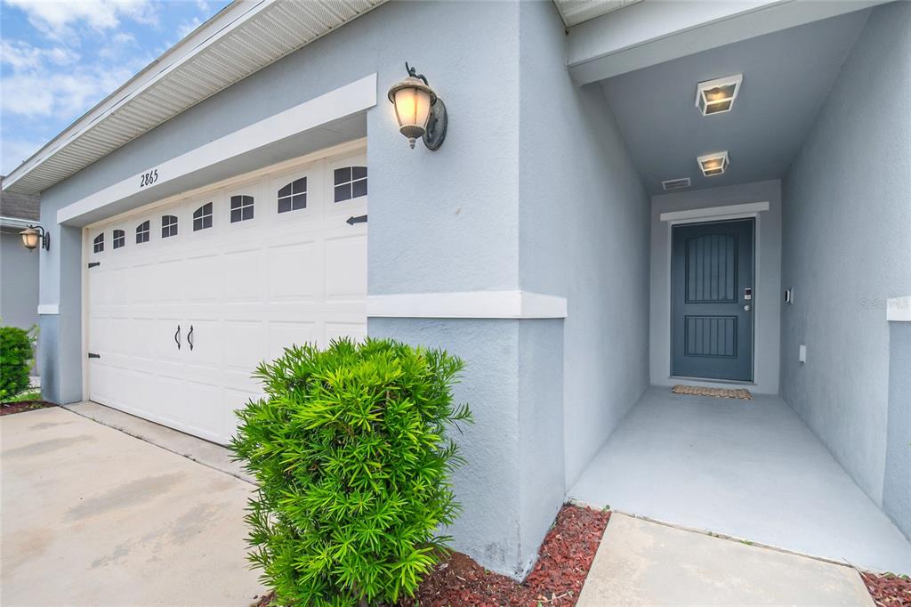 A living room features tan leather furniture, a glass coffee table, and a media console — 2865 MOSSHIRE CIRCLE, ST CLOUD, FL