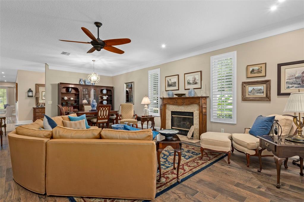 A living room with a tan sectional sofa, fireplace, dining area, and hardwood flooring — 6264 W GLYNBORNE LOOP, CRYSTAL RIVER, FL