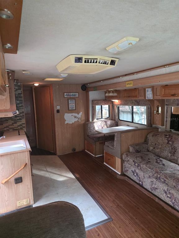 An interior view of a recreational vehicle featuring a kitchenette, dining booth, and sofa — 3000 CLARCONA ROAD UNIT 770, APOPKA, FL