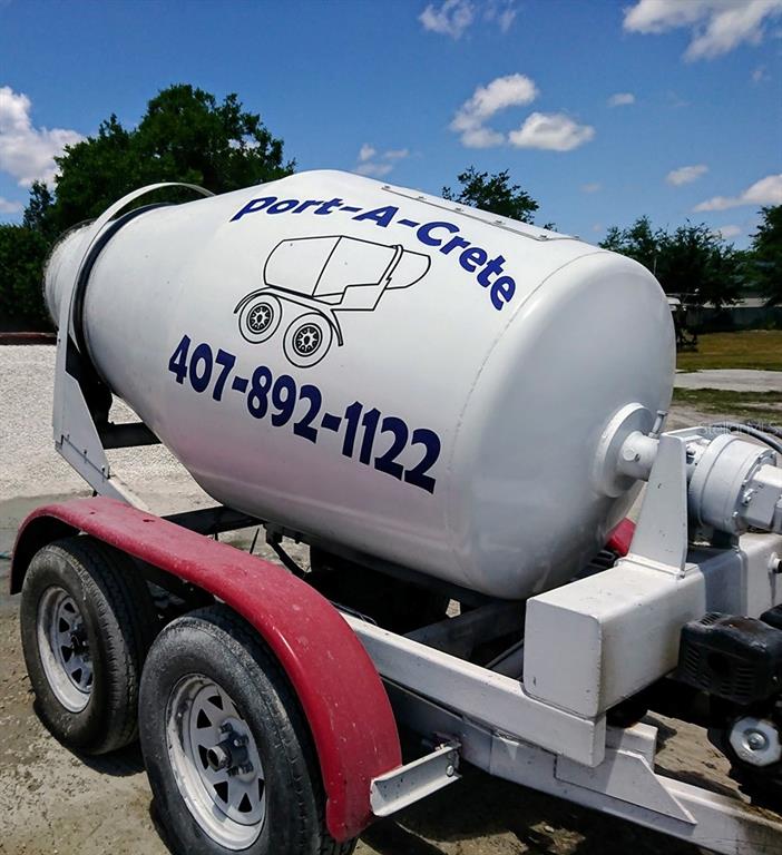 A white portable concrete mixer trailer sits outdoors under a blue sky — 99999 EASTERN AVENUE, ST CLOUD, FL