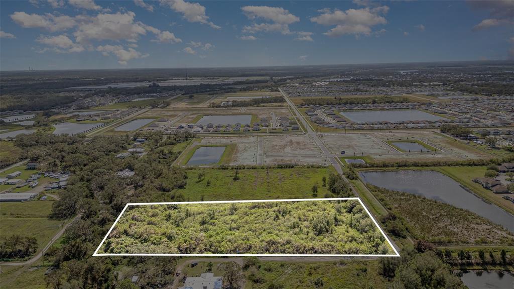 An aerial view shows a rectangular, undeveloped plot of land outlined in white — 12TH STREET SE, RUSKIN, FL