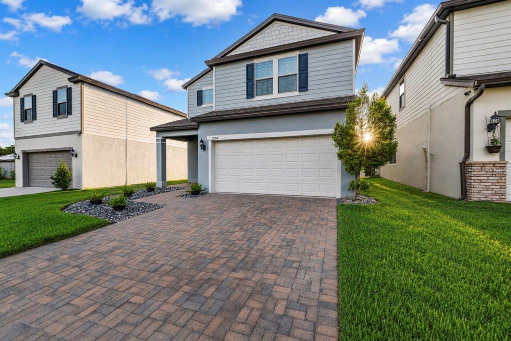 A two-story suburban house with a paved driveway, a two-car garage, and a grassy lawn — 2704 VISTA VERDE LANE, KISSIMMEE, FL