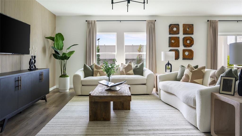 A living room features two white sofas, a wooden coffee table, and a slatted wall — 34620 SILENT PINE RUN, DADE CITY, FL