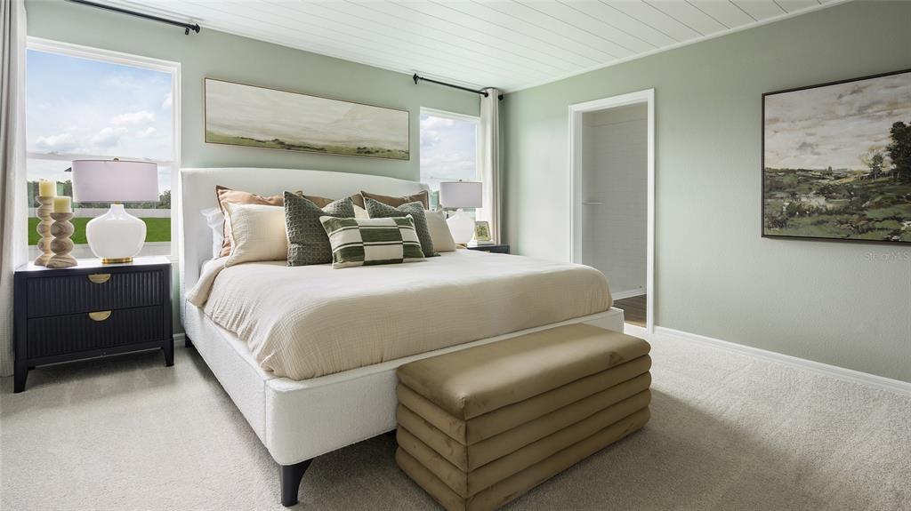 A bedroom features a white upholstered bed, a dark nightstand, and light green walls — 34620 SILENT PINE RUN, DADE CITY, FL