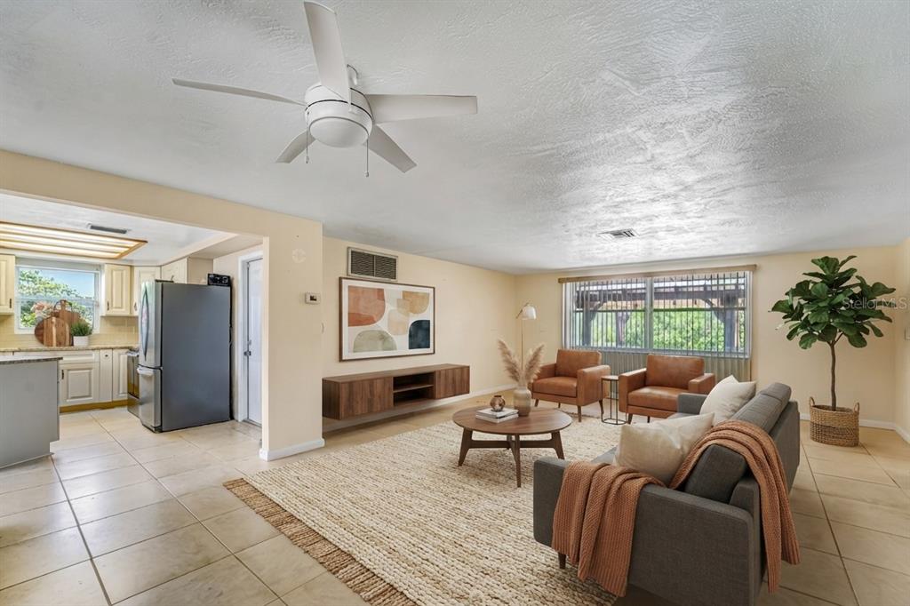A kitchen features cream-colored cabinets, granite countertops, a subway tile backsplash, and stainless steel appliances — 8542 BETTY STREET, PORT RICHEY, FL