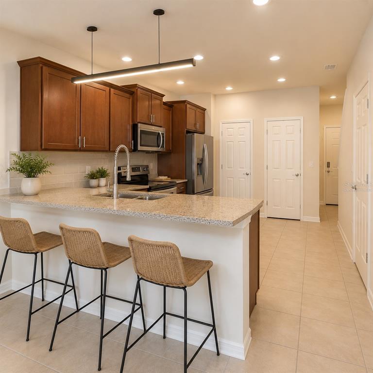 A kitchen features wooden cabinets, granite countertops, a breakfast bar with stools, and tile flooring — 5368 SYLVESTER LOOP, TAMPA, FL