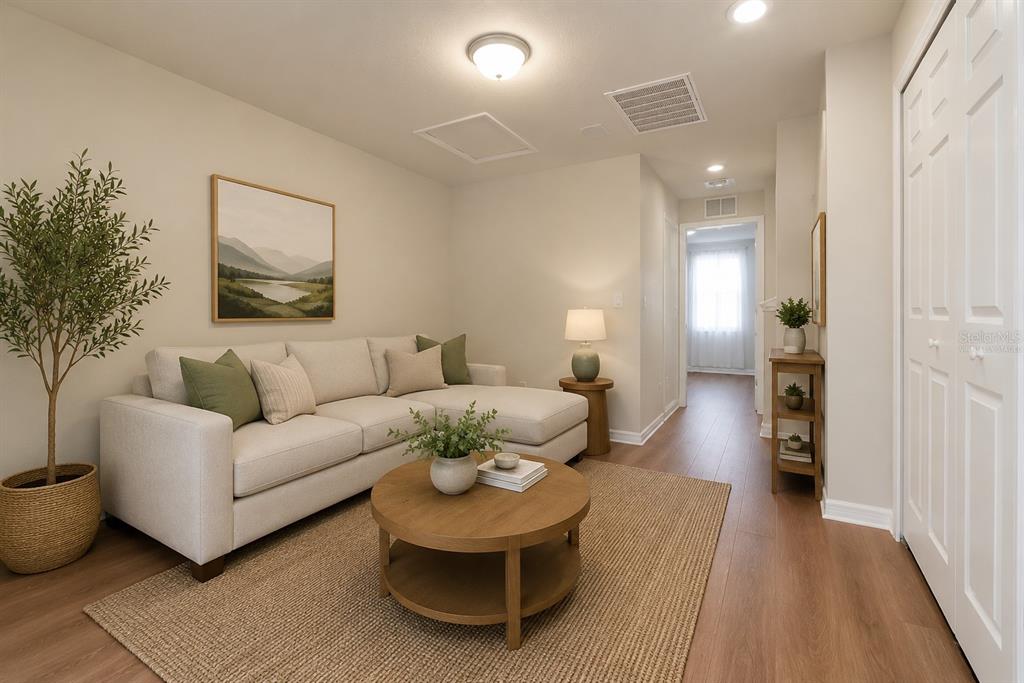 A living room features a beige sectional sofa, a round wooden coffee table, and wood flooring — 5368 SYLVESTER LOOP, TAMPA, FL