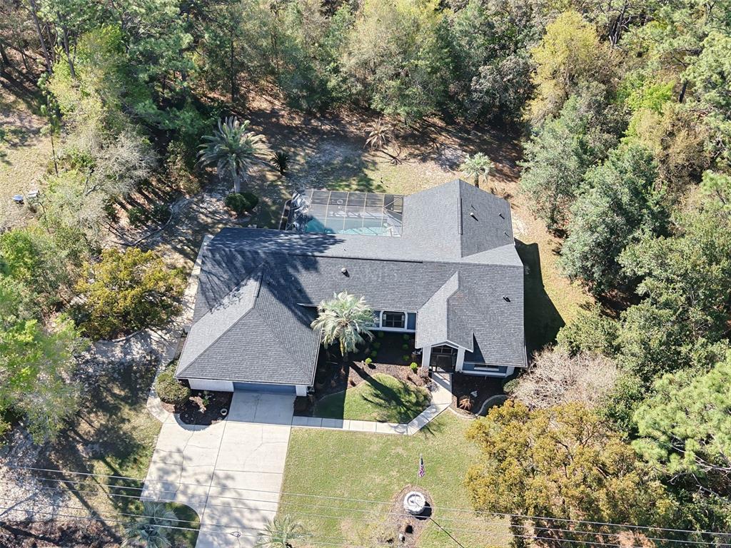 An aerial view shows a house with a screened pool and a wooded backyard — 2298 W PINE RIDGE BOULEVARD, BEVERLY HILLS, FL