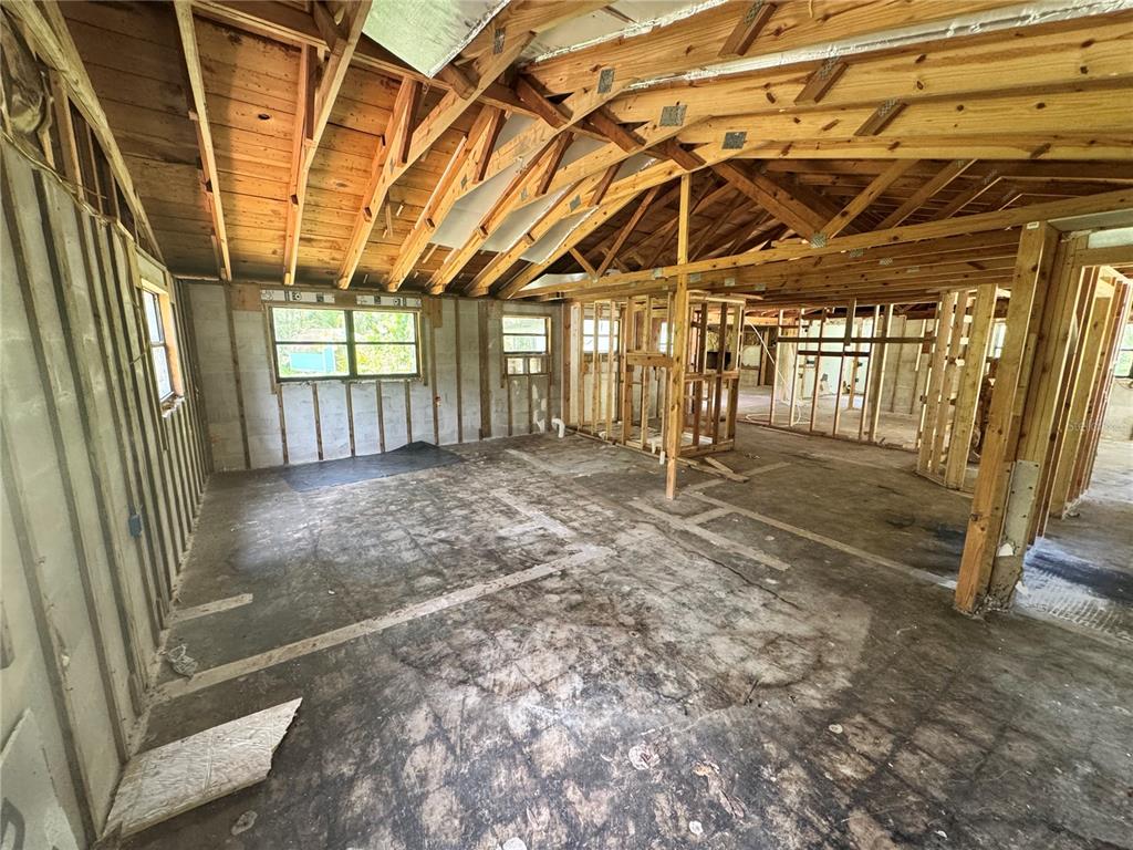 An unfinished room with exposed wood framing, concrete block walls, and a dirt floor — 9010 MAIDEN LANE, ARIPEKA, FL