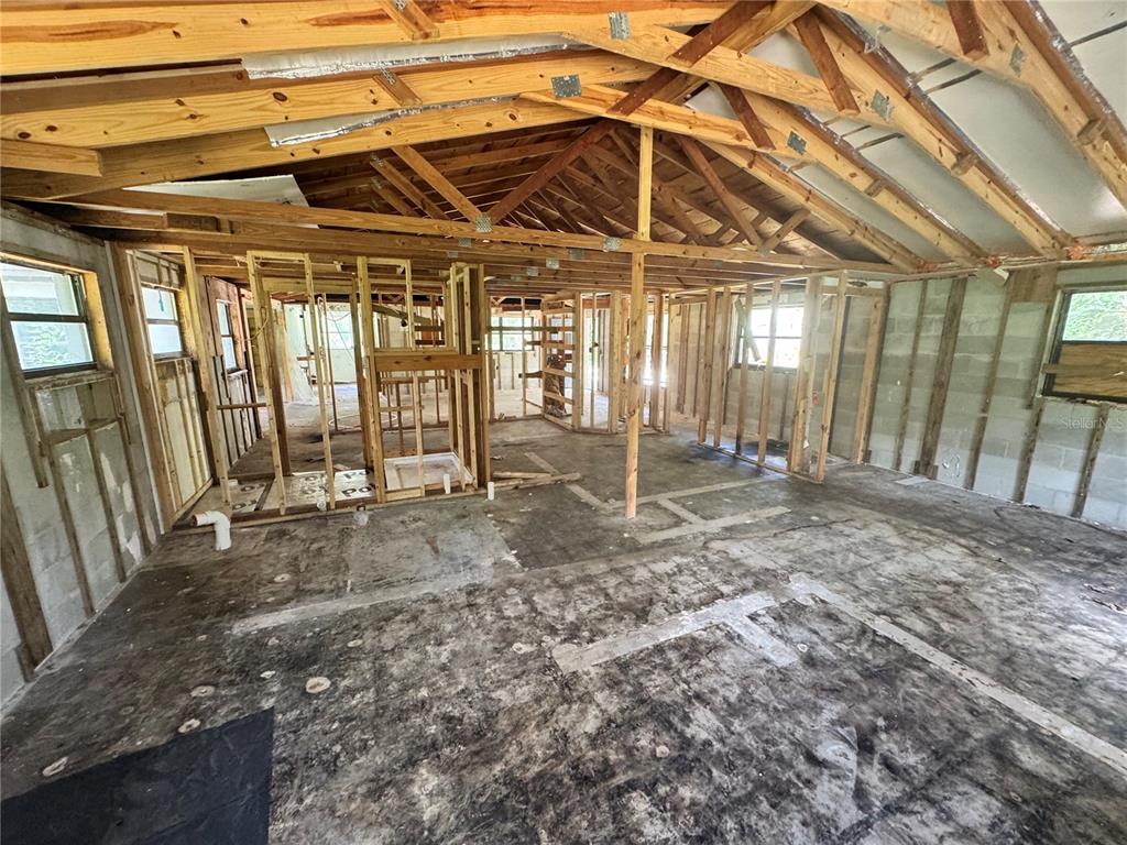 An interior view of a house under construction with exposed wood framing and concrete walls — 9010 MAIDEN LANE, ARIPEKA, FL