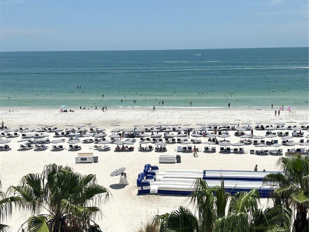 A high-angle view of a sandy beach filled with umbrellas, lounge chairs, and people — 5500 GULF BOULEVARD UNIT 7221, ST PETE BEACH, FL
