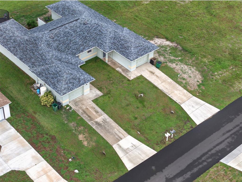 An aerial view shows a single-story house with two garages and a shared driveway — 1223/1225 NE 15TH LANE, CAPE CORAL, FL