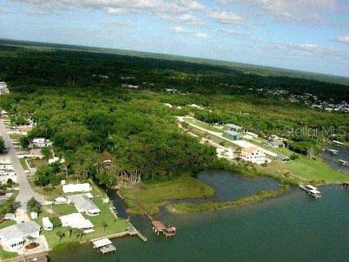An aerial view shows waterfront homes, a small inlet, and a large wooded area — MYRTLE STREET, EDGEWATER, FL