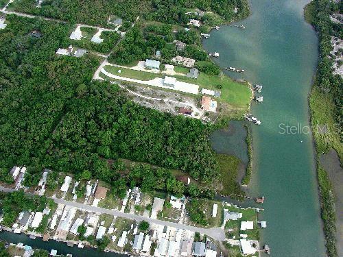 An aerial view shows a residential area with homes, dense trees, and a waterway — MYRTLE STREET, EDGEWATER, FL