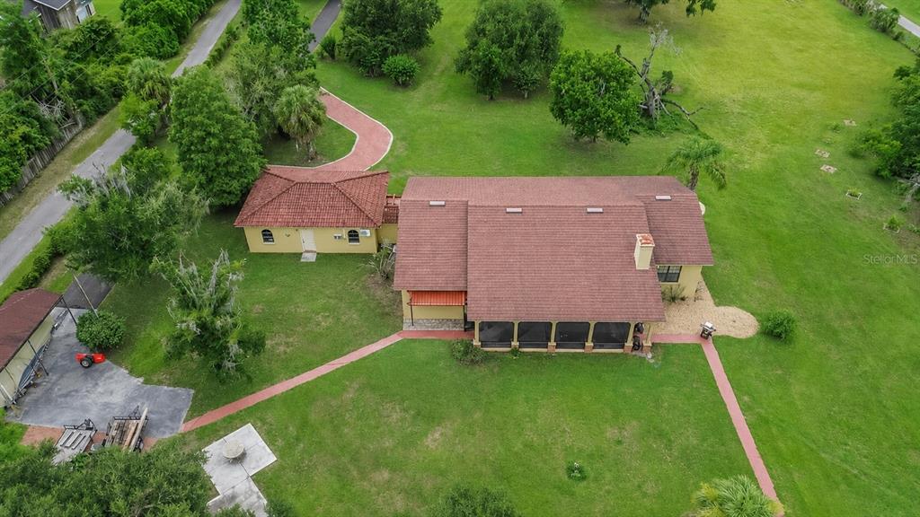A paved driveway leads through a large, grassy yard toward mature oak trees — 4020 N WILDER ROAD, PLANT CITY, FL