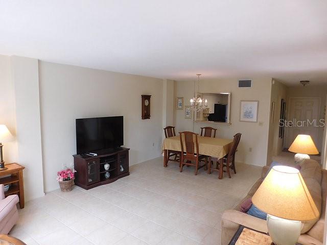 A living and dining area with tile floors, a television console, and a dining set — 716 GRANADA AVENUE UNIT 302, VENICE, FL