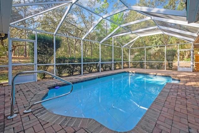 A screened-in swimming pool with a brick paver deck surrounded by trees — 340 E SAVOY STREET, LECANTO, FL
