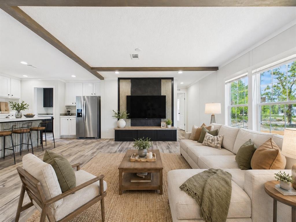 A tan manufactured home features a wooden staircase leading to a white entry door — 137 BEULAH DRIVE, HAWTHORNE, FL