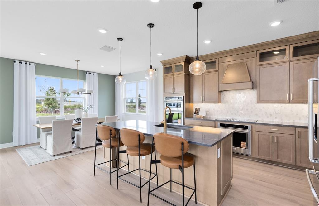 A kitchen with a central island, bar stools, and an adjacent dining area — 1538 VALIER POINT, ZEPHYRHILLS, FL