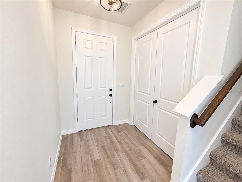 A modern kitchen features white cabinetry, a central island, and wood-look tile flooring — 2077 DERWENT DRIVE, DAVENPORT, FL