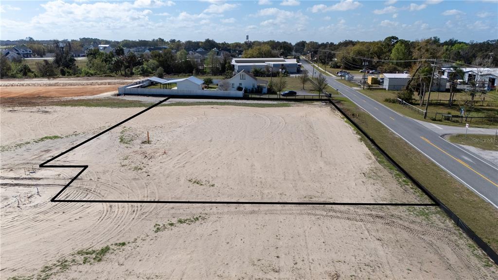 An aerial view shows a vacant, sandy lot outlined in black next to a paved road — 32768 DUNNE ROAD, SAN ANTONIO, FL