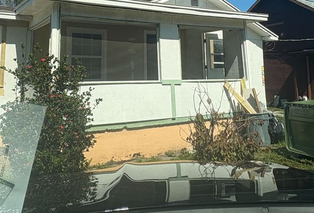 A white house exterior features a screened-in front porch and a tan foundation — 2509 DIXIE AVENUE, SARASOTA, FL
