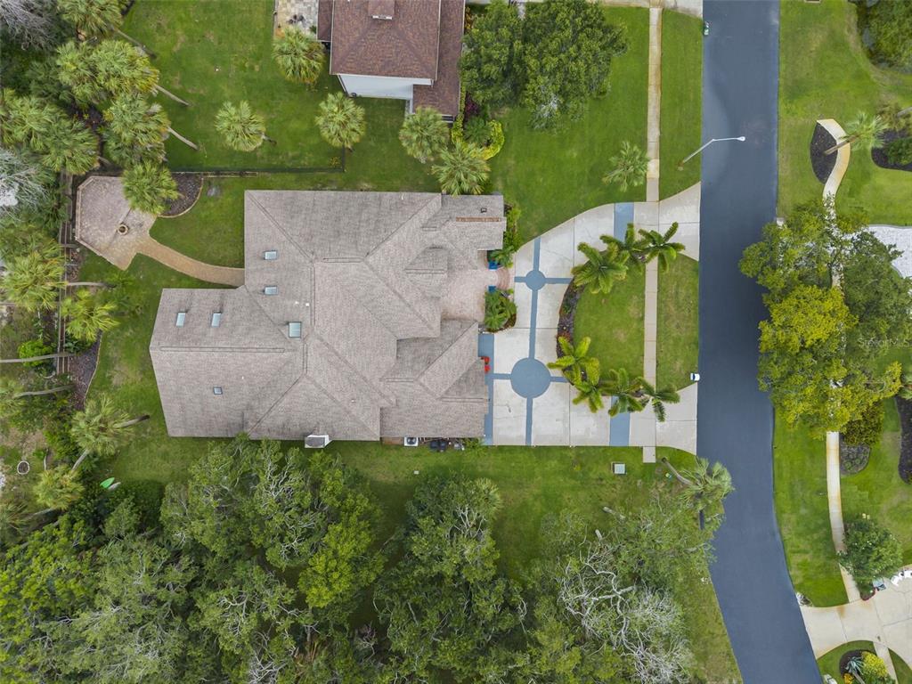 An aerial view shows a house with a shingled roof, circular driveway, and surrounding landscaping — 1705 MEYERS COVE DRIVE, TARPON SPRINGS, FL