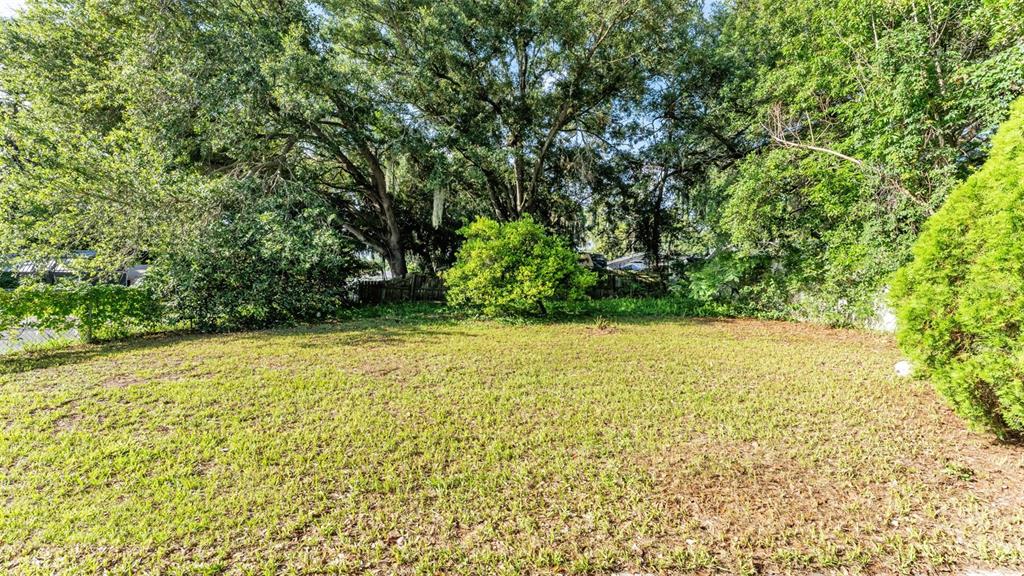 A living room with a sectional sofa, armchair, and an open kitchen with bar seating — 861 E LOWELL STREET, LAKELAND, FL